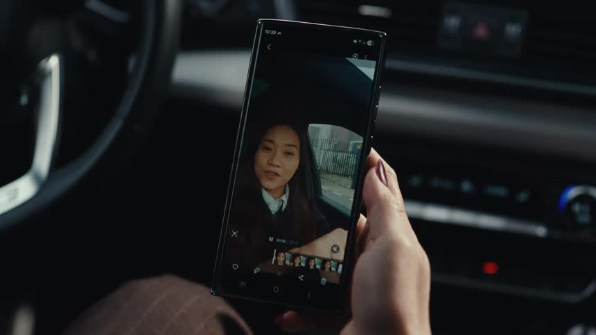 The woman plays a video on her cell phone