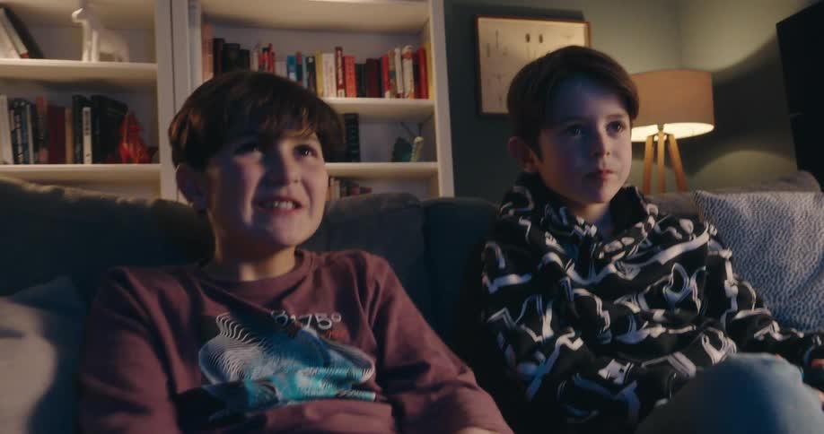 Two kids cheer while playing video games
