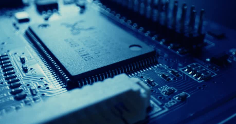 Blue lighting shines onto the circuit board of a piece of electronic equipment