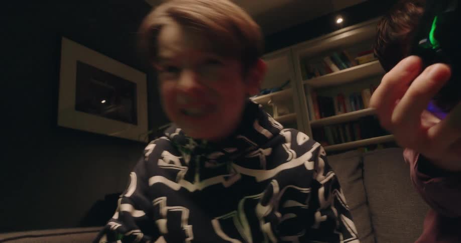 Boys play a video game while sitting in the living room