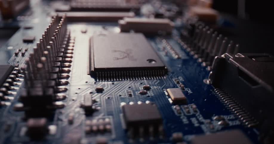Various microchips and electronic components are featured on a blue circuit board