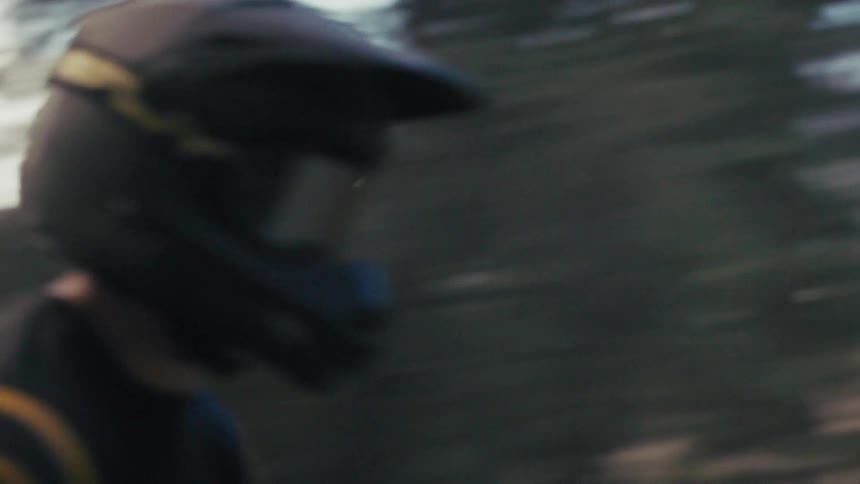 Motocross rider riding on a forest trail with motion blur effect
