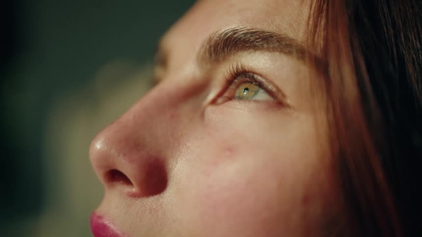 Closeup of a female face focusing on eyes lit by natural side light