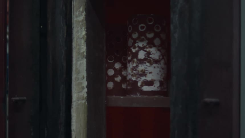 Perforated metal cylinders placed inside redpainted compartment