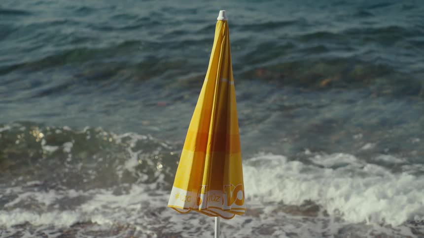 The yellow umbrella is on the beach