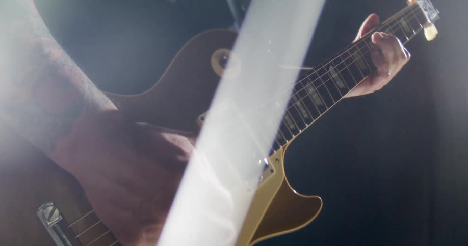 Musicians hand playing an electric guitar in closeup