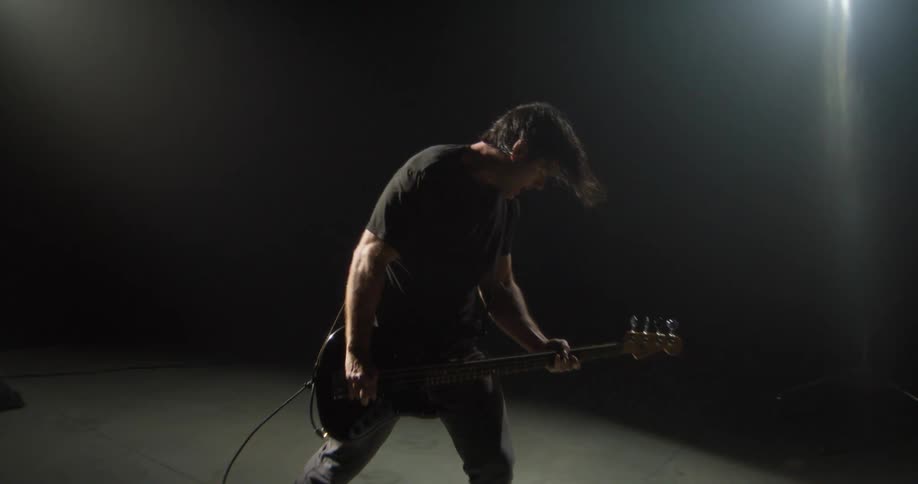 A musician plays an electric guitar in slow motion