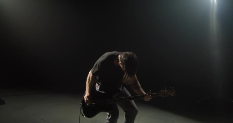 A man playing bass in a studio