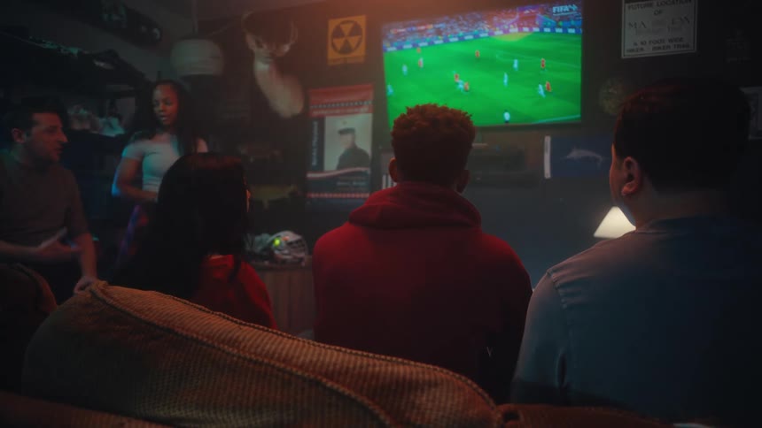 People sitting in a bar watching a soccer game on television