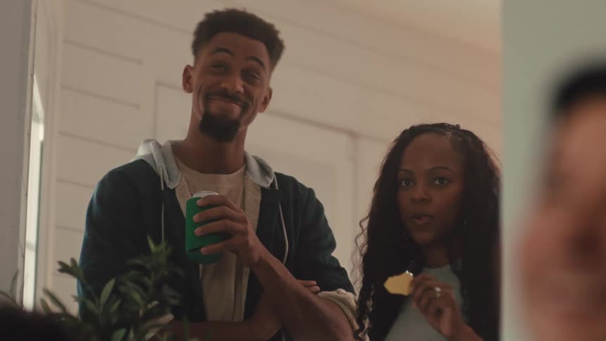 The man and woman drink and eat at a party