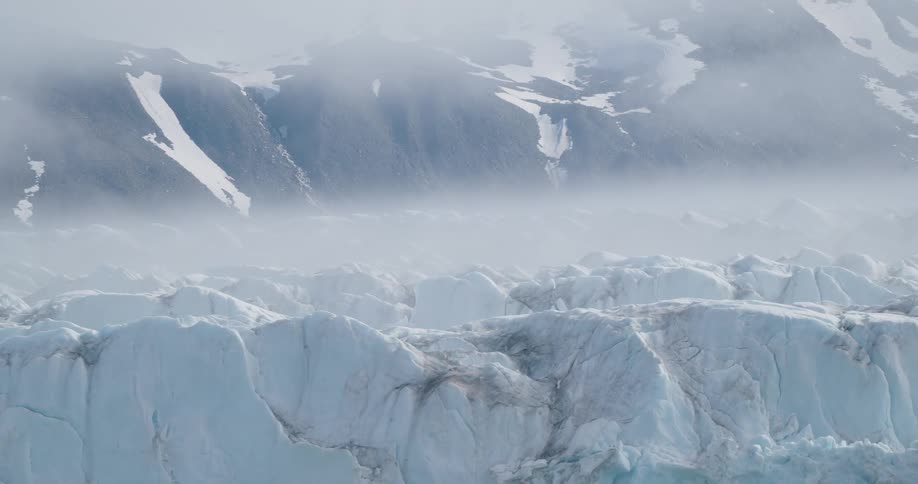 A large glacier is at the bottom of a mountain range