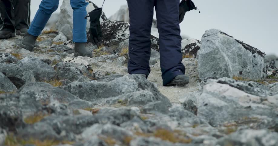 The tourists carefully hike over the rocks