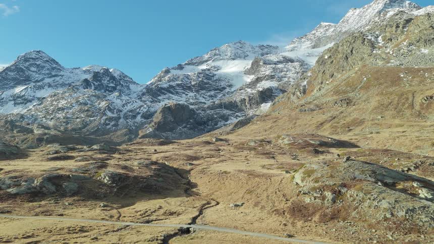 An aerial view of a mountain range with some snow covered peaks