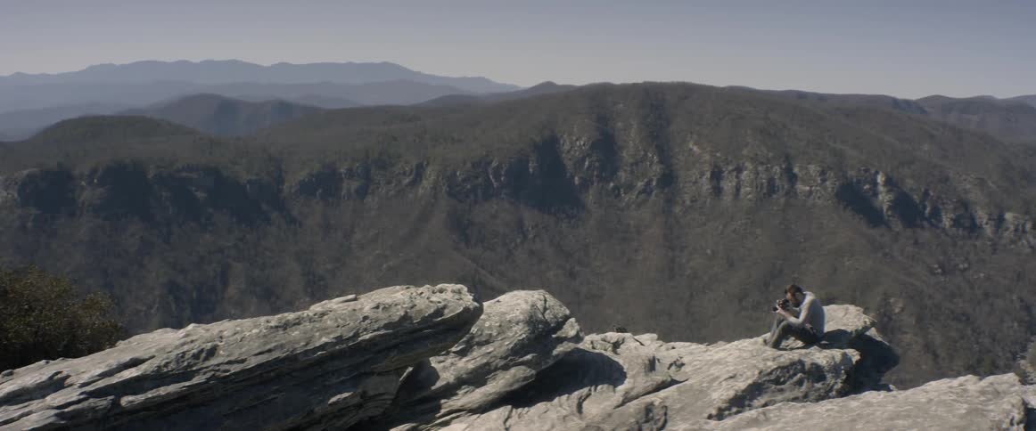 A man sits atop a rock mountain