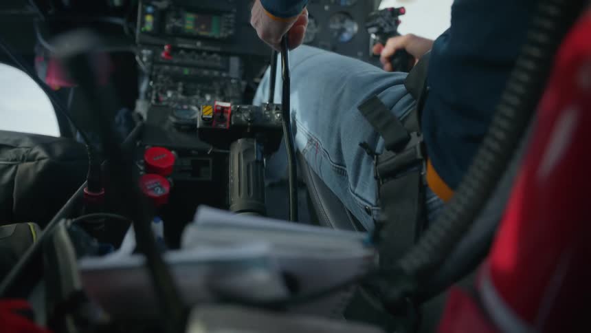 A pilot grips the control stick inside an aircraft cockpit during active flight