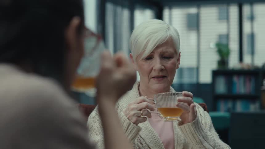 Two women having tea while sitting in a room