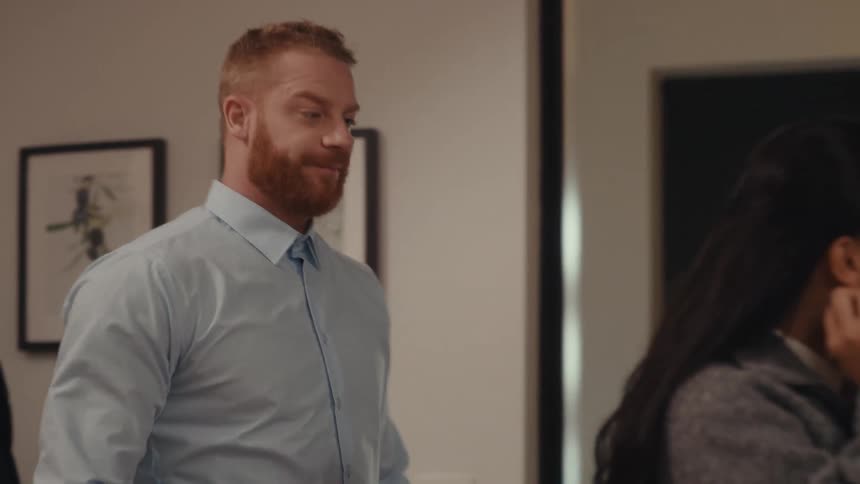 A man enters his home and removes his jacket before kissing a woman on her cheek