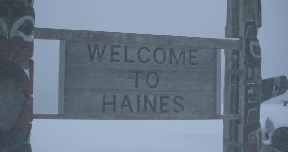Snow falling in front of a sign