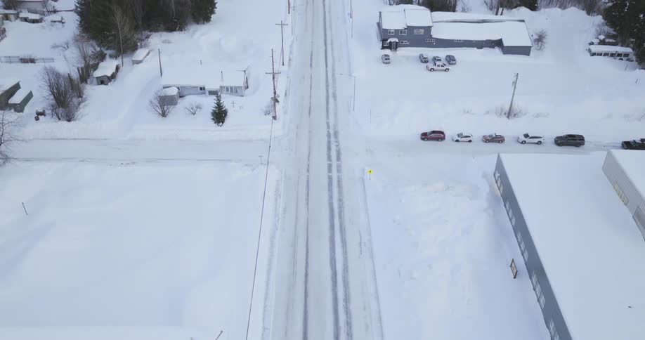 Snowcovered town with a main road and buildings seen from an aerial view