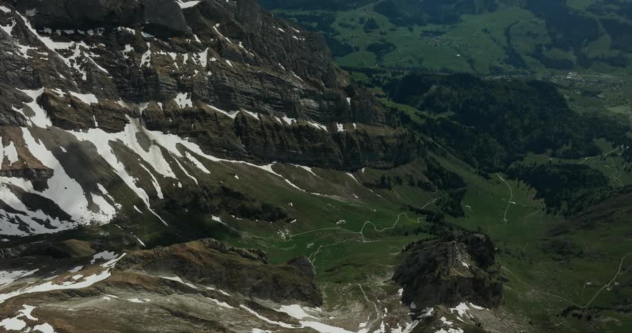 An aerial view of a mountain range with snow on it