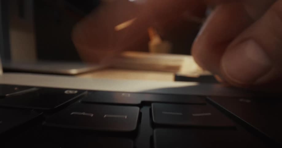 Hand typing on a laptop keyboard on a work desk