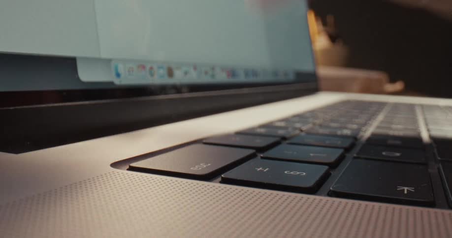 Finger pressing a laptop keyboard key near the screen