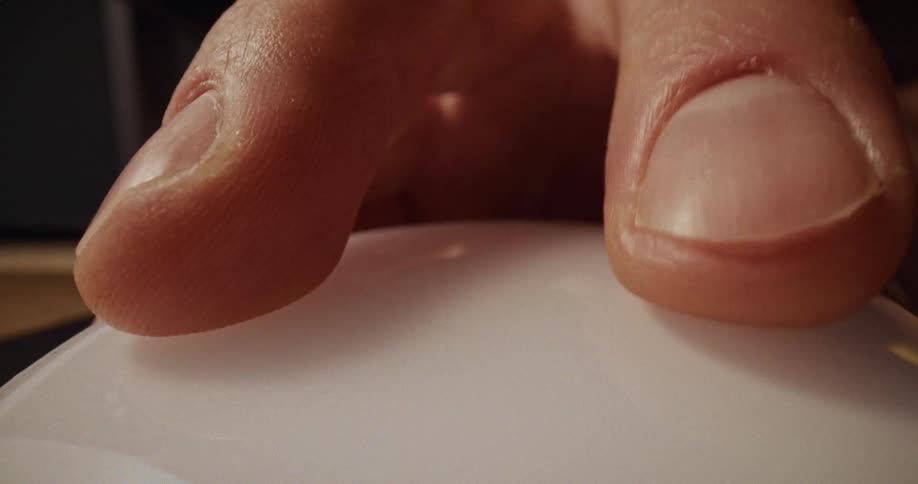 Person manipulates a small white computer mouse