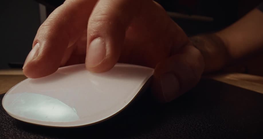 Hand clicking a wireless mouse on a work desk
