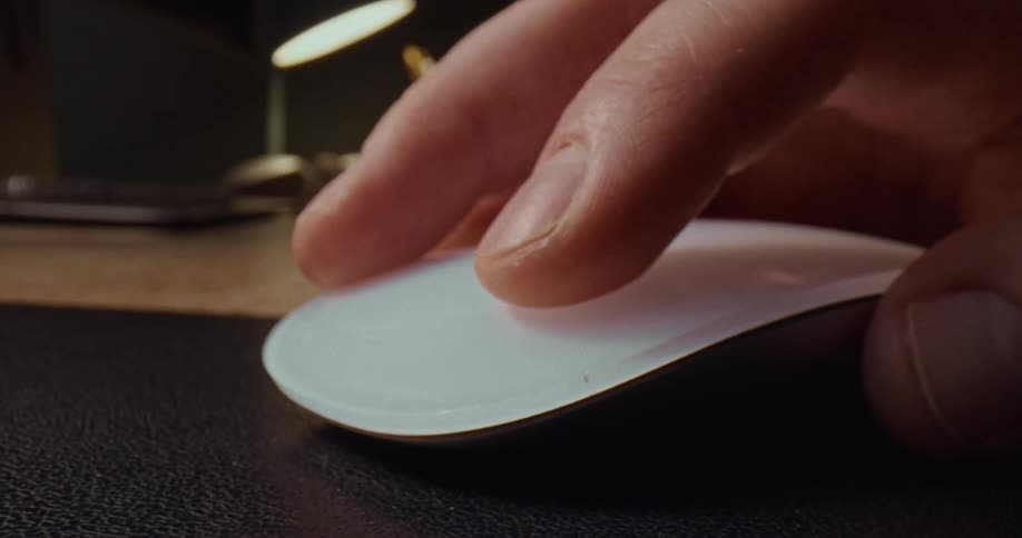 Hand clicking a wireless mouse on a work desk