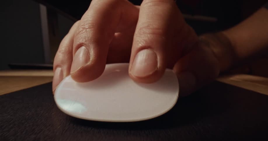 Hand moving a computer mouse on the mouse pad