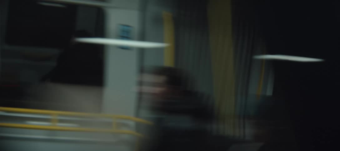 Train stopped at a station with doors and interior visible in blur