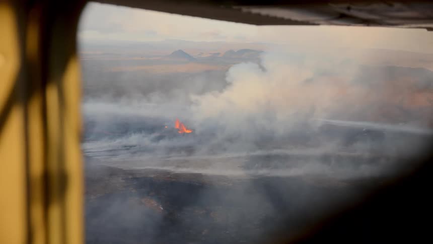 Aerial view reveals forest fire with thick smoke near the mountains