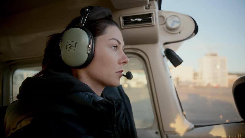 Pilot wears a communication headset inside a light aircraft cockpit during ground operation