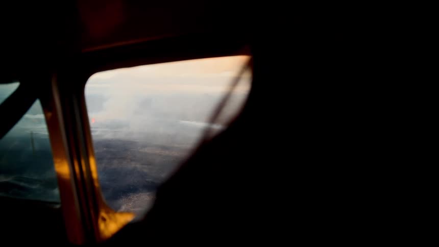 The cockpit in the plane is dark as it flies