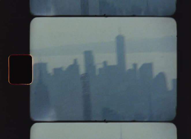 The video features a grainy vintagestyle film scan of the new york city skyline showcasing the silhouettes of skyscrapers through a hazy atmosphere it captures a nostalgic aesthetic with visible film reels and light leaks focusing on the iconic shape