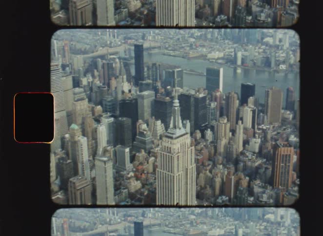 Empire state building dominates manhattan skyline in aerial view with retro film frame
