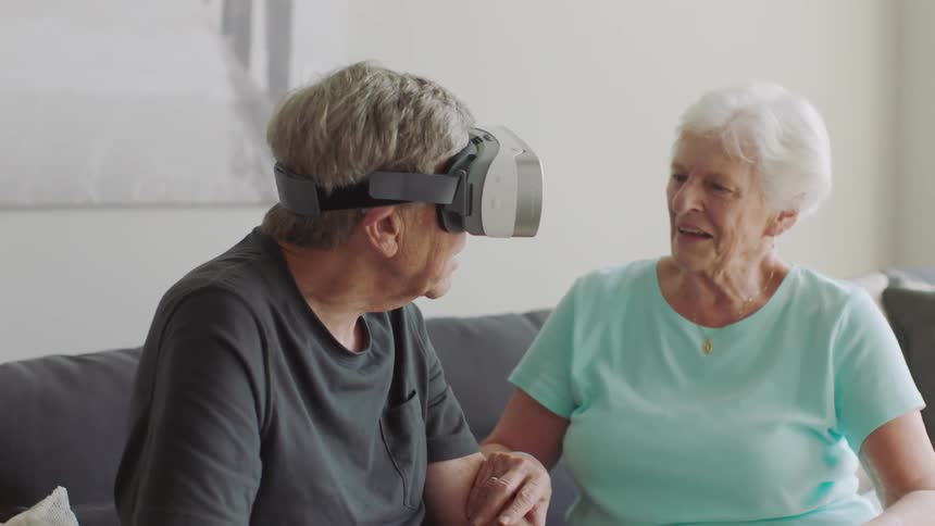 A man wearing a vr headset sits on the couch