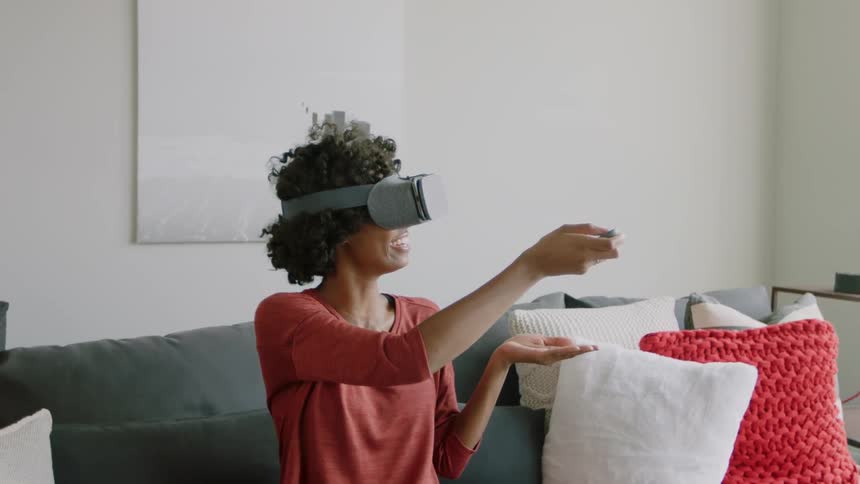 Woman enjoying a virtual reality experience while sitting on a couch