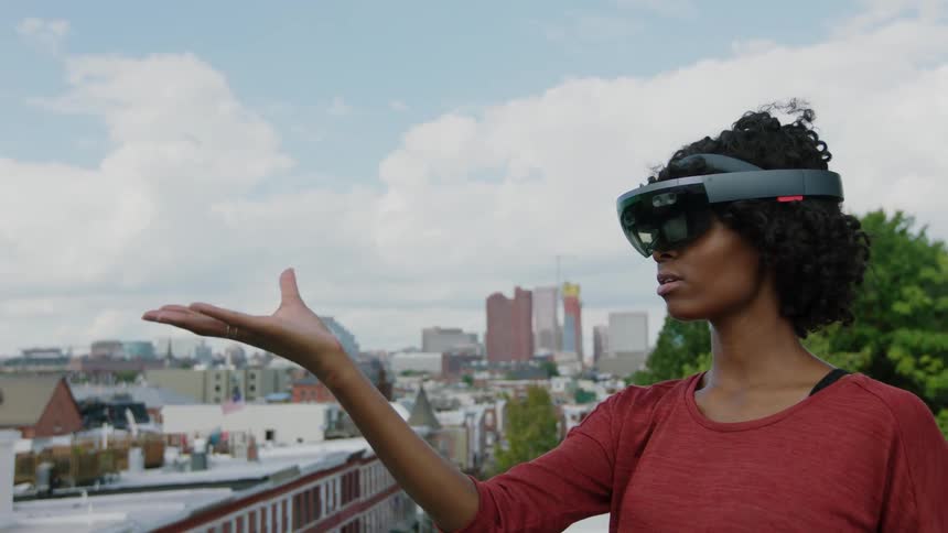 A woman is using a virtual reality headset on a roof