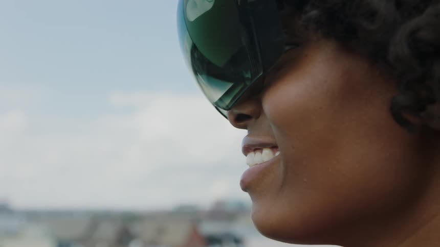 A woman smiles wearing a vr headset