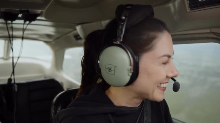 The woman smiles while flying the airplane