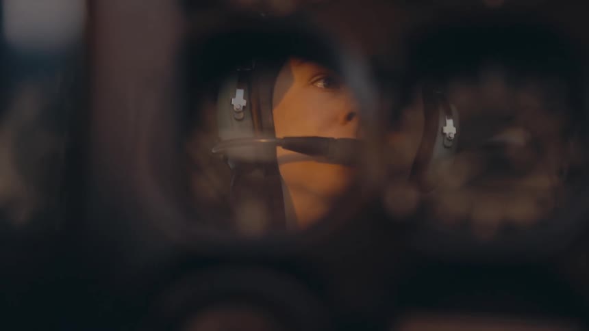Face reflection with headset on cockpit surface lit by golden light