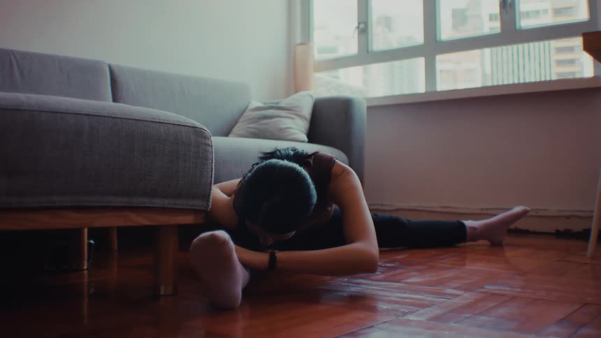 The woman leans and stretches while doing yoga