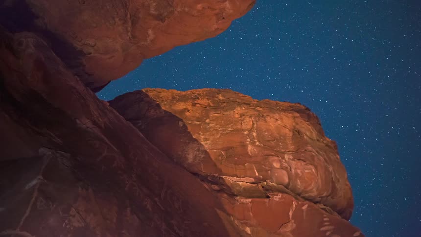 Mountain rocks with stars moving across a clear sky