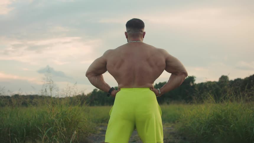 A man flexing and modeling outdoors