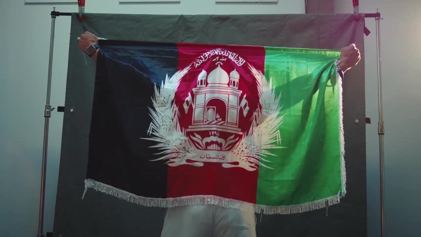 The man models with a flag around his back