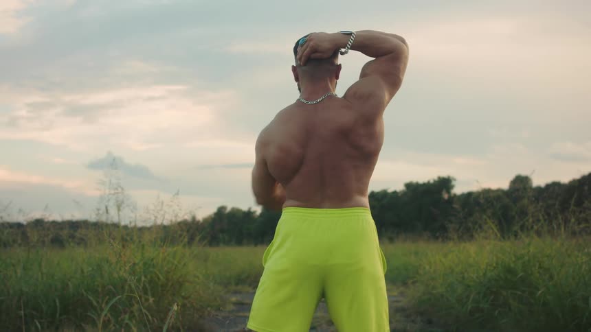 A man flexing and showing off outdoors