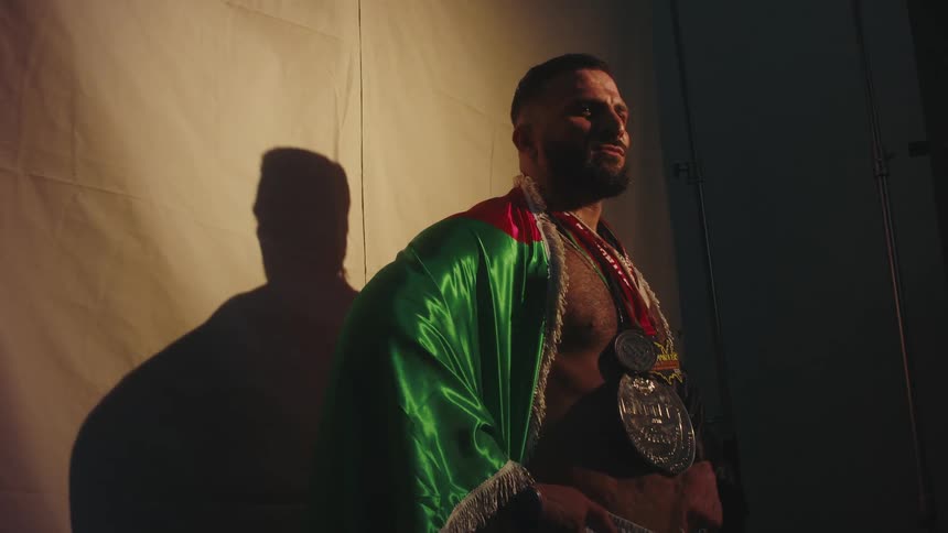 Muscular athlete with medals around his neck wrapped in the mexican flag