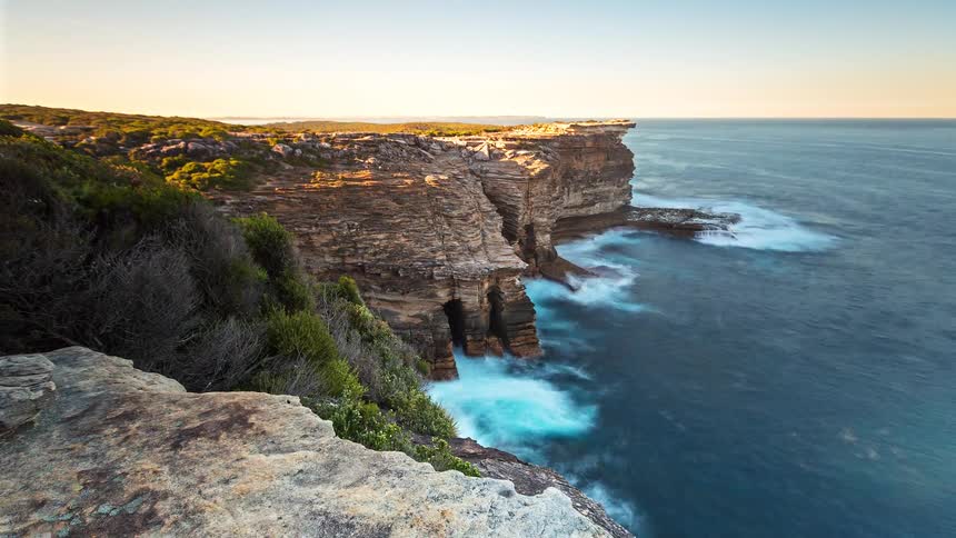 Waves crash against the island shoreline