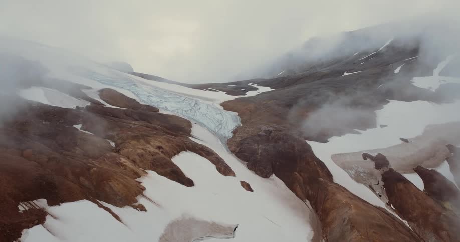Fog covers the snow covered mountain